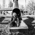 Young boy enjoying a tunnel slide at a park
