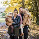Autumn family portrait by a river with golden trees