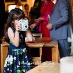 Young girl taking a photo of cakes at a wedding reception