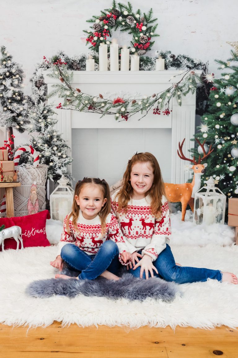 Two young sisters at a Christmas themed studio photography session
