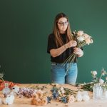 Studio photoshoot with a florist organising flowers into a bouquet.