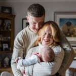 New parents holding their newborn baby at home