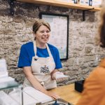 Amber Lee of the Cheese Press Richmond serving a customer in her shop.