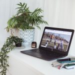 photo of a laptop open on a white desk with a website loaded on screen.