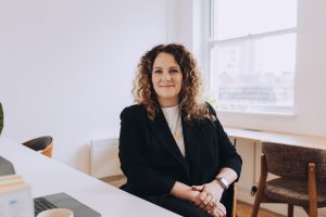 Working headshot of a business women sitting in an office.