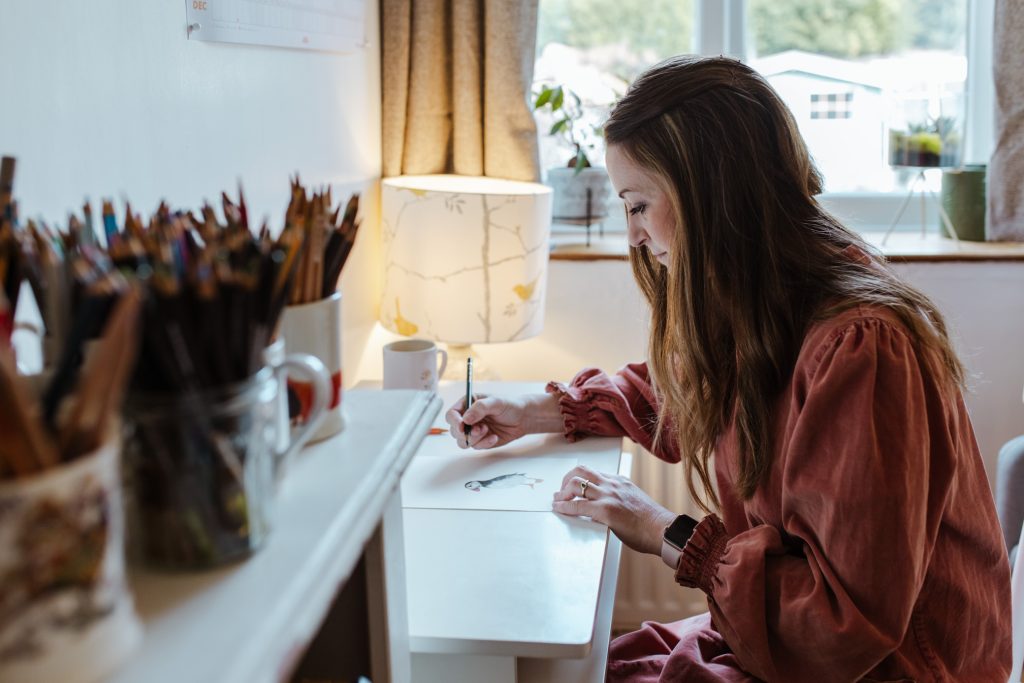 Female artist sketching in her home studio.